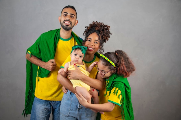 Afro family gathered with Brazilian clothes playing for the country