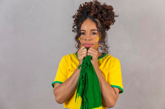 Afro girl cheering for favorite brazilian team holding national flag