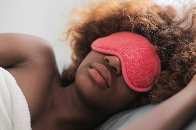 Afro girl sleeping with a mask