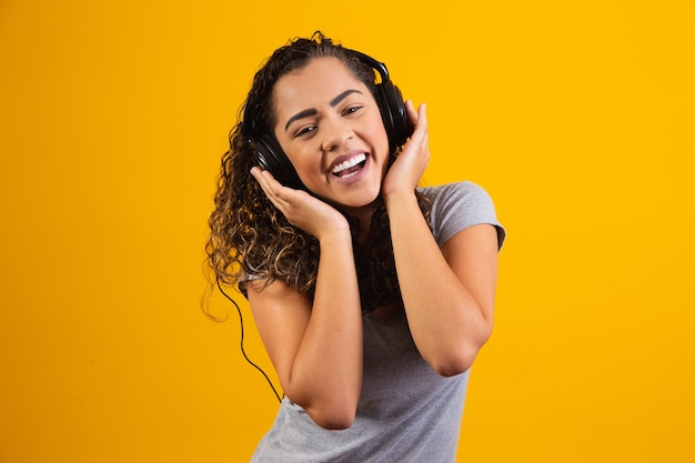 Afro jong meisje met haar koptelefoon luisteren naar muziek