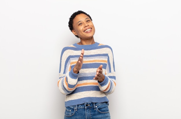 Afro jonge zwarte vrouw voelt zich gelukkig en succesvol, lacht en klapt in handen, zegt gefeliciteerd met een applaus