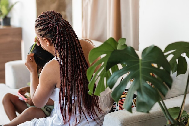 Foto afro-latijnse erfenis colombiaanse liefde moeder kamt het haar van haar dochters