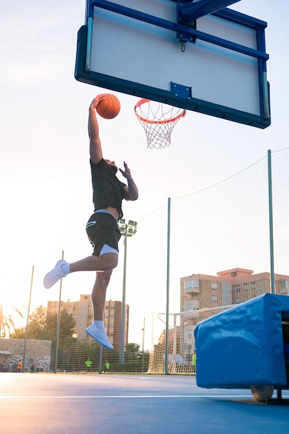 Afro Latin man jump and dunks the ball on a basketball court