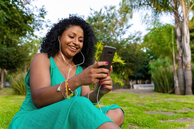 Afro latina vrouw met koptelefoon en mobiel