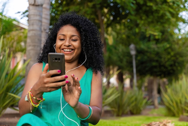 Afro latina woman with headphones and mobile