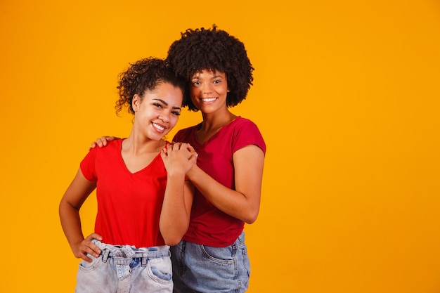 Afro lesbisch koppel op geel. homo-affectieve koppel