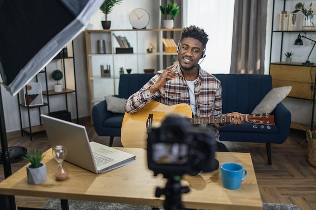 Afro-man die gitaar speelt en het streamt met een videocamera