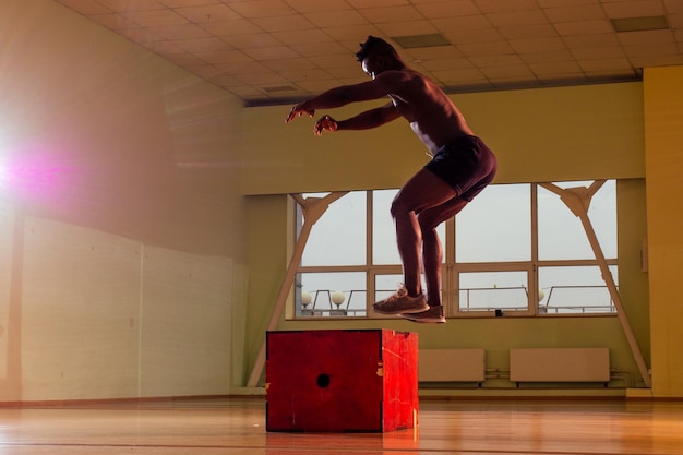 Afro man doet oefening met een fitbox in een sportschool