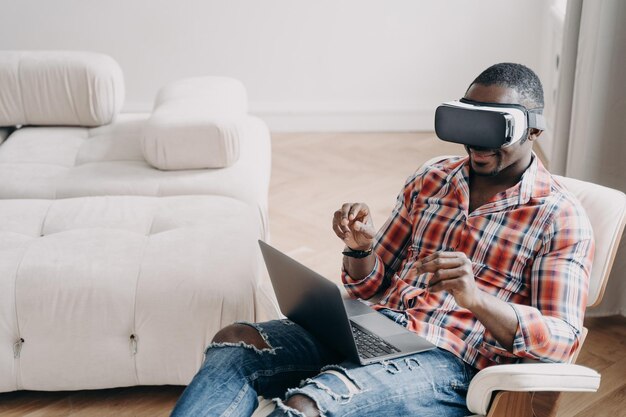 Afro-man in vr-headset op kantoor aan huis Ontspannen freelancer zittend in een stoel en bezig met project