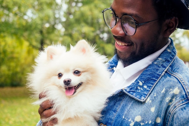 Afro man knuffelen zijn pluizige spits in park