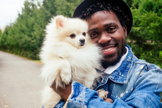 Afro man knuffelen zijn pluizige spits in park