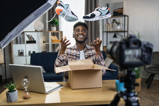 Afro man unboxing sneakers for creating video content