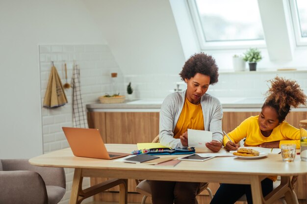 Afro-moeder die haar dochter bijstaat met huiswerk