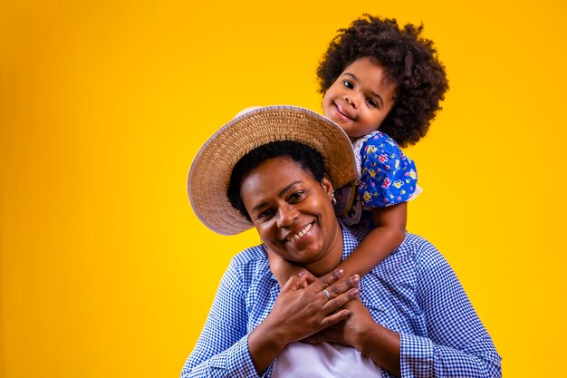 Afro mother and daughter dressed for june party