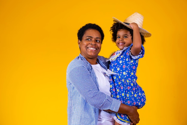 Afro mother and daughter dressed for june party