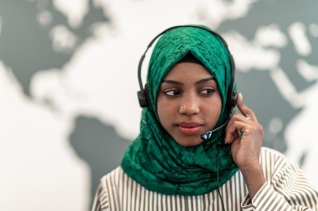 Afro muslim female with green hijab scarf customer representative business woman with phone headset ...