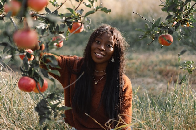 Afro vrouw in appelbomen boomgaard