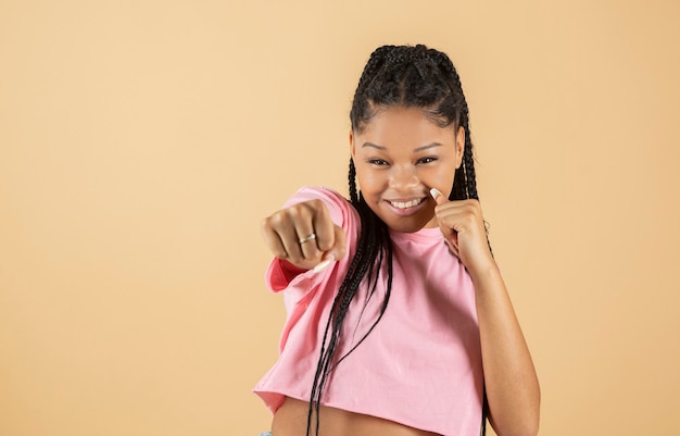 Afro vrouw maakt punch gebaar op gele achtergrond