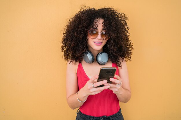 Afro vrouw met behulp van haar mobiele telefoon.