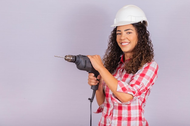 Afro vrouw met een elektrische boor op witte achtergrond.