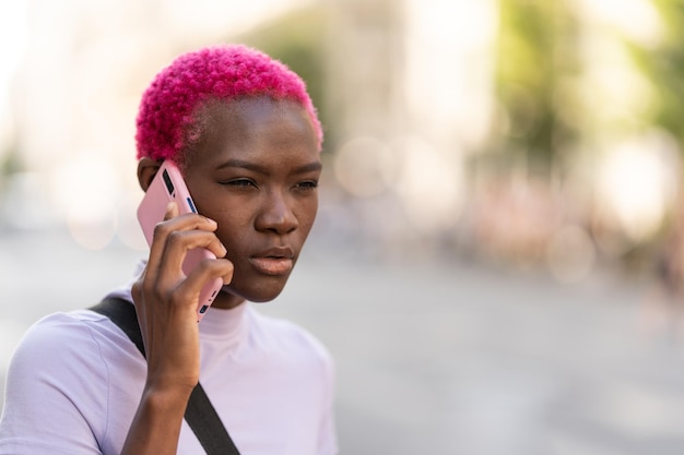 Afro-vrouw met een wantrouwende uitdrukking die op een mobiel praat