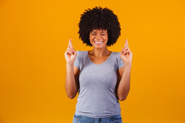 Afro-vrouw met gekruiste vingers juichende overwinning