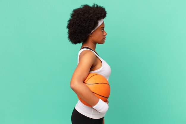 Afro-vrouw op profielweergave die ruimte vooruit wil kopiëren, denken, fantaseren of dagdromen. basketbal concept