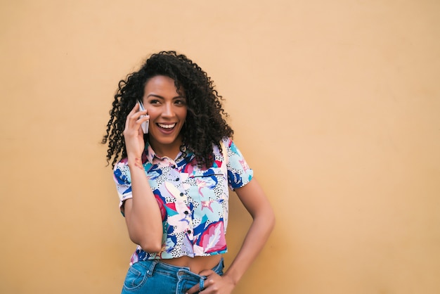 Afro vrouw praten aan de telefoon.