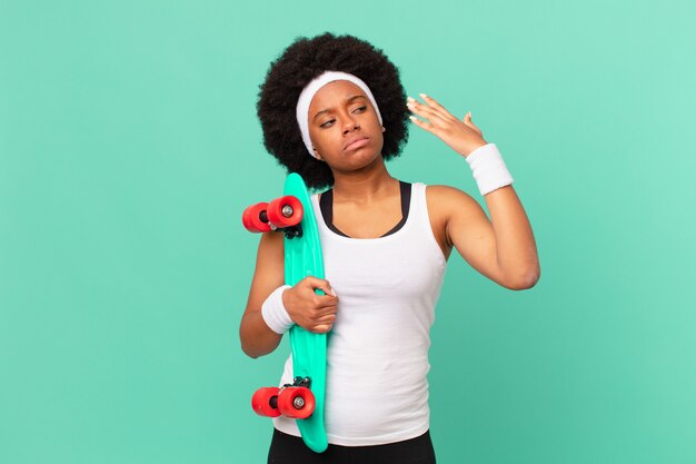 Afro-vrouw voelt zich gestrest, angstig, moe en gefrustreerd, trekt aan de nek van het shirt, ziet er gefrustreerd uit met een probleem. skateboard concept