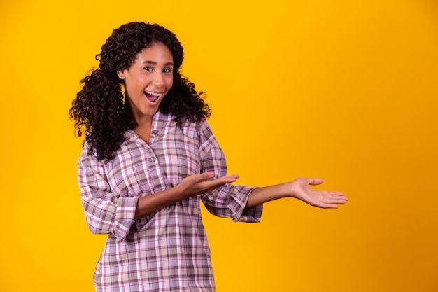 Foto donna afro vestita con un vestito da festa junina che indica lo spazio libero laterale per il testo