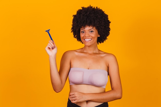 Afro woman holding in hand a razor blade