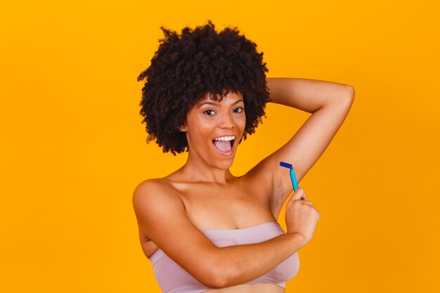 Afro woman holding in hand a razor blade