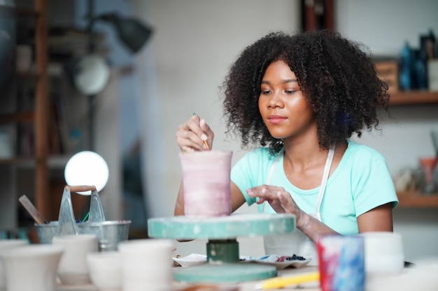 写真 ワーク ショップで陶器を作るアフロの女性