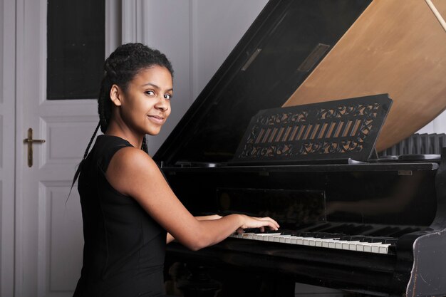 Afro woman playing on a piano