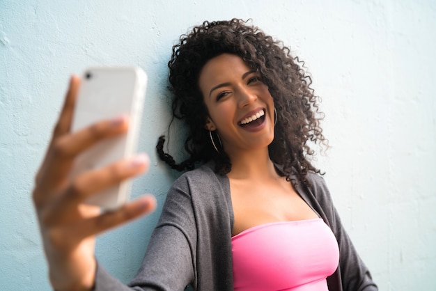 Afro woman taking selfies with phone