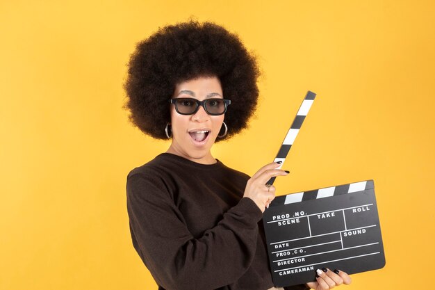 Afro woman with 3d glasses and clapperboard, cinema movie concept