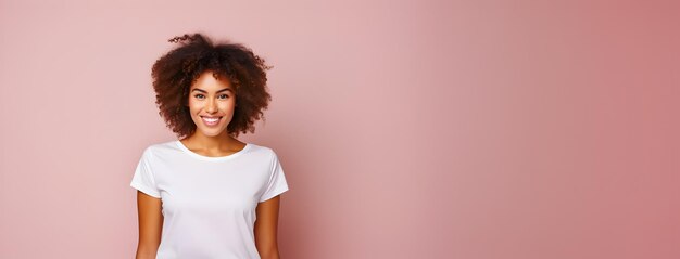 Foto donna afro con i capelli ricci con un'espressione positiva che indossa una maglietta bianca casuale sullo sfondo rosa