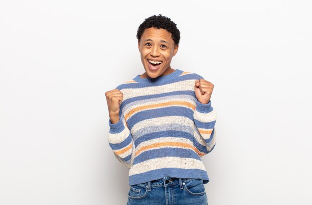 Afro young black woman feeling happy, relaxed and satisfied, showing approval with okay gesture, smiling