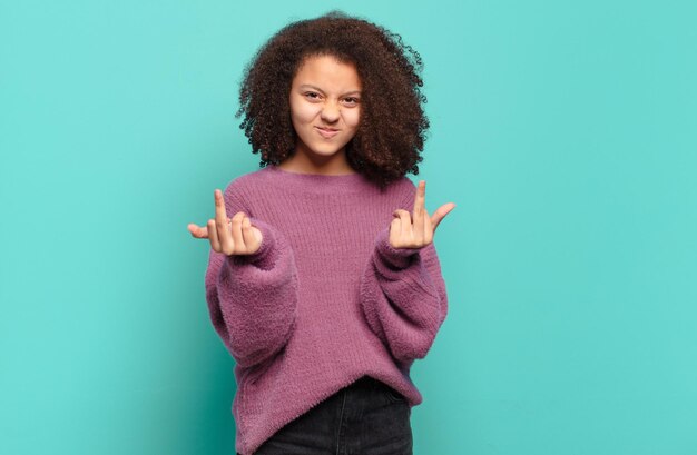 afro young girl against flat color wall