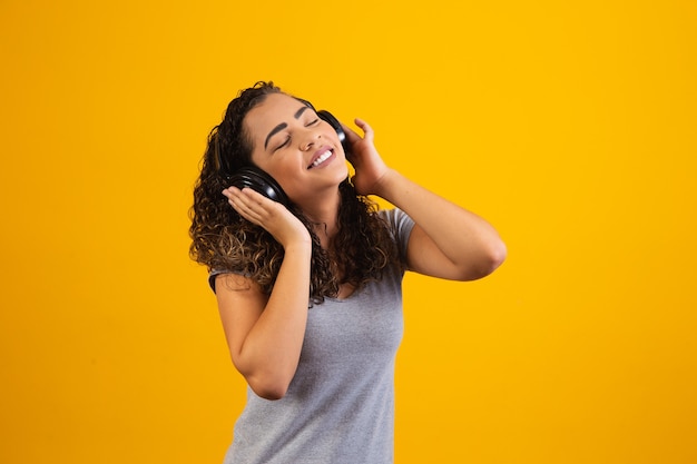 Afro young girl with her headphones listening to music