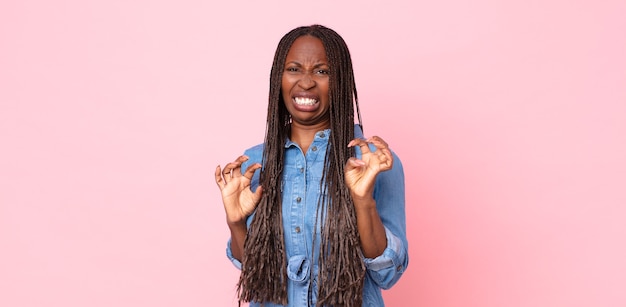 Afro-zwarte volwassen vrouw die walgt en misselijk is, zich terugtrekt van iets smerigs, stinkends of stinkends en zegt bah