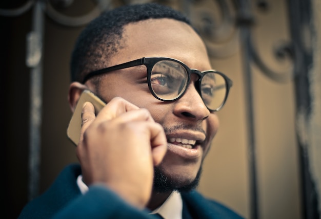 Afrozakenman die op de telefoon spreekt