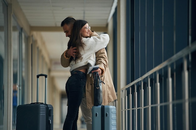 Afscheid nemen, elkaar omhelzen. Het echtpaar is samen in de hal van de luchthaven.