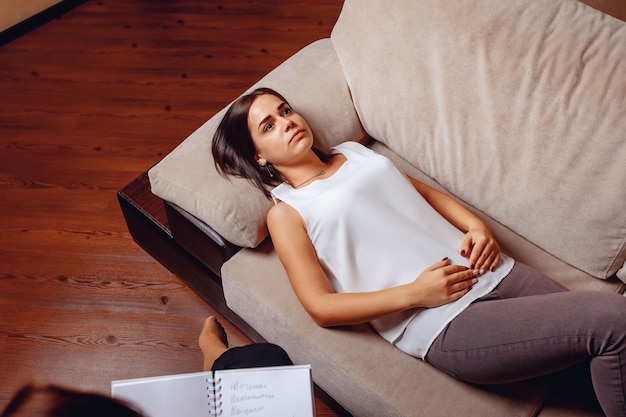 Afspraak met een psycholoog. Cam ontspannen vrouw liggend zonder emoties op een bank bij een psycholoog. Psychotherapie.