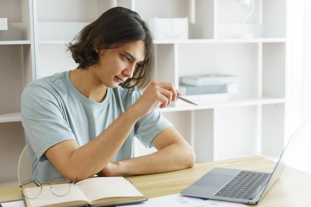 Afstandsonderwijs concept Tienerjongen studeren en wijzen naar grafiek terwijl les wiskunde les online