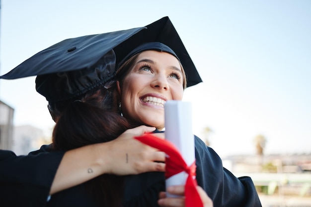 Afstudeervrouwen en studenten vieren prestatie met een knuffel in toga en succesvol samen als afgestudeerden Mockup-ruimte gelukkige vrouwen en meisjes omhelzen elkaar om diploma of certificaat te ontvangen