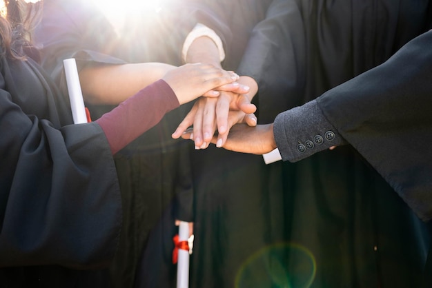 Afstuderen afgestudeerde viering en handen samen en ondersteuningsdiploma met gemeenschaps- en universiteitsmensen prestatie Universitair diploma onderwijs en leergroei met ceremonie en solidariteit