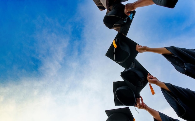 Afstuderen Caps in de lucht gegooid succes afgestudeerden van de universiteitConcept onderwijs felicitatie afgestudeerden aan de universiteit