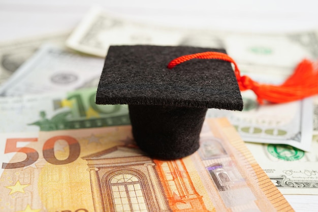 Afstuderen gap hoed op Euro en Amerikaanse dollar bankbiljetten geld Onderwijs studiekosten leren leren concept