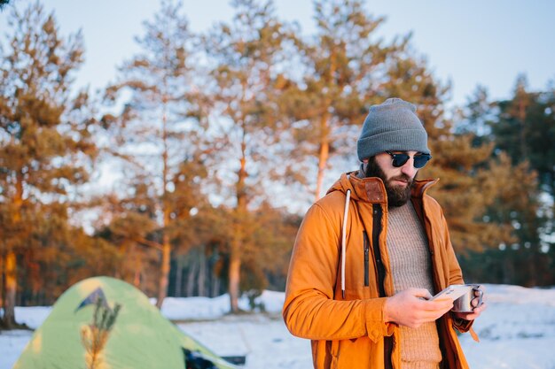 登山後、観光客はテントの近くに立ってお茶やコーヒーを飲みながら夕日を眺め、携帯電話で写真を撮ります。